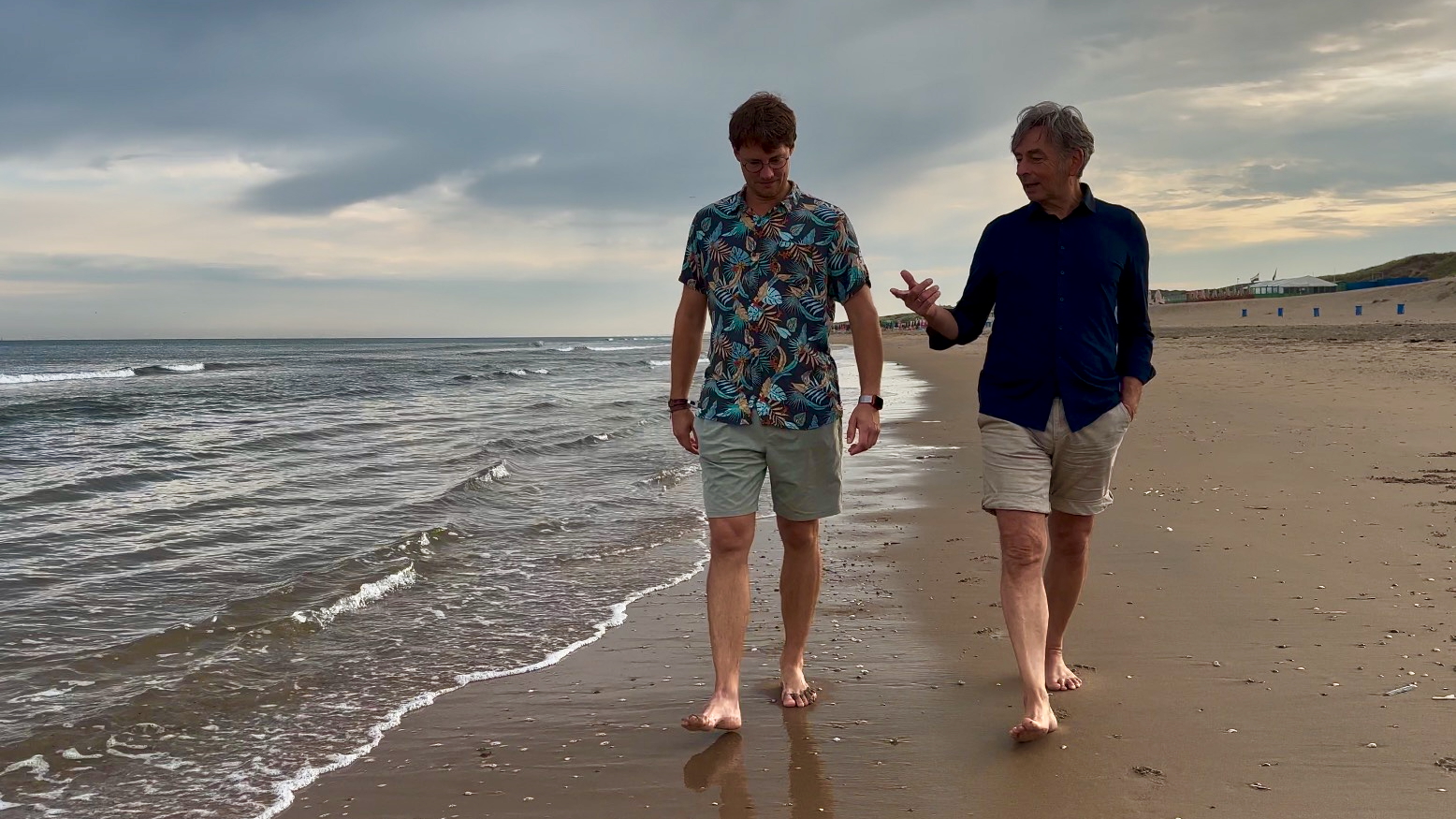 Zwei Menschen barfuß im Gespräch am Strand der Nordsee